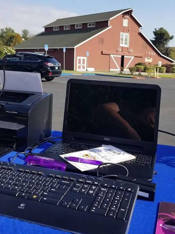 A laptop and keyboard on the ground outside.