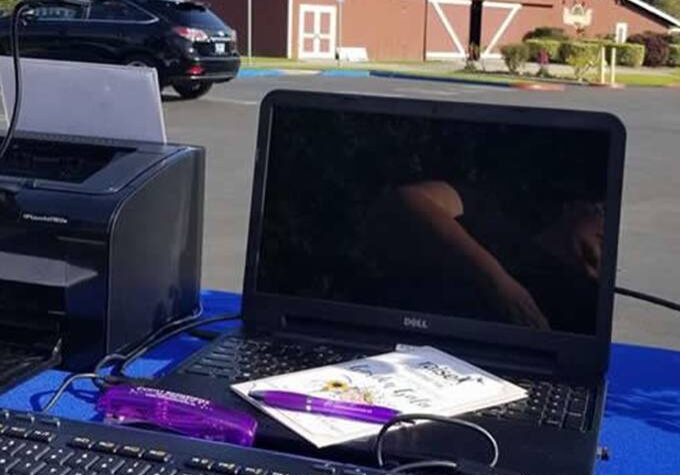 A laptop and keyboard on the ground outside.